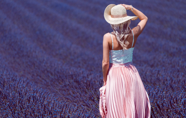 Красивая девушка в шляпе на лавандовом поле 