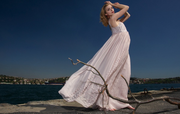 Красивая девушка в белом платье на берегу реки