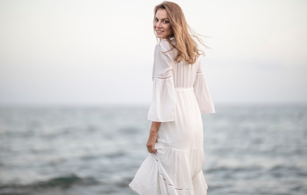 Красивая девушка в белом платье у моря