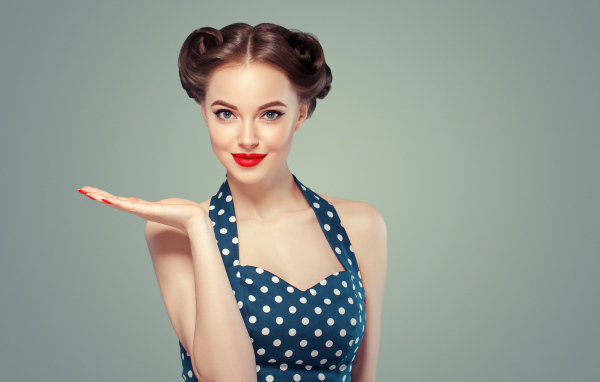 Красивая девушка в платье в горошек на сером фоне