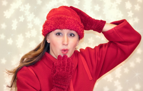 Красивая девушка в красном шлет воздушный поцелуй