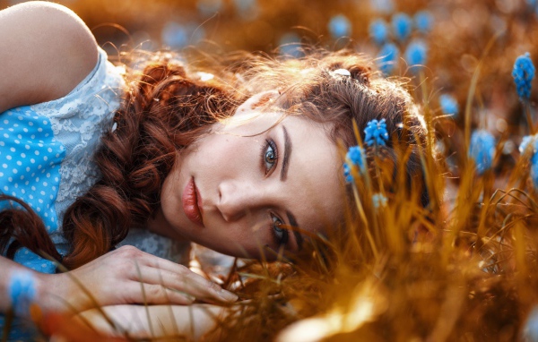 Красивая девушка на земле с мускариками