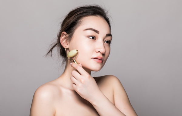 Красивая девушка разглаживает кожу лица