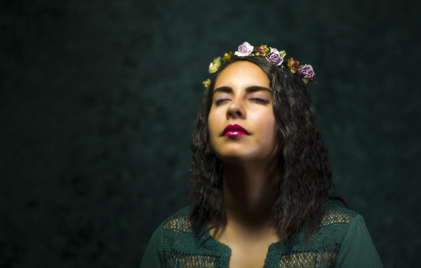 Красивая девушка с закрытыми глазами с венком на голове 