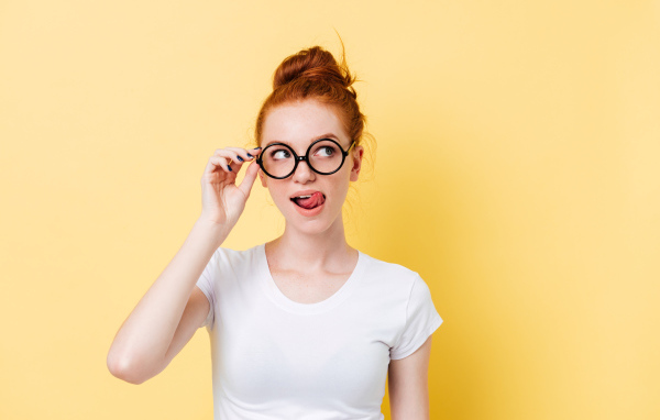 Красивая девушка в очках на желтом фоне 