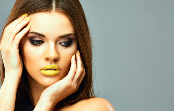 Красивая девушка с желтыми губами на сером фоне
