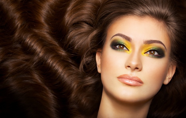 Красивая длинноволосая девушка с ярким макияжем на глазах 