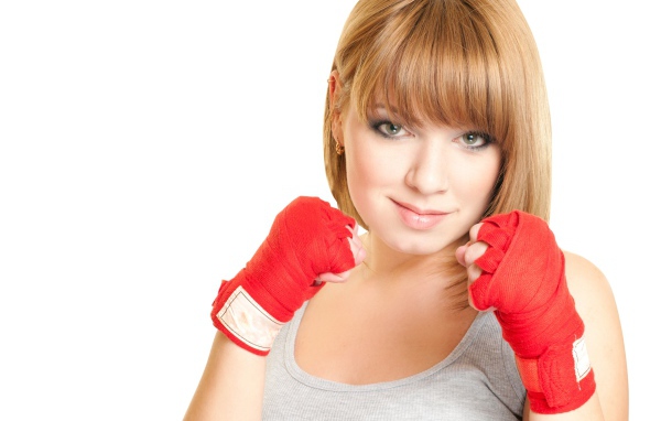 Красивая рыжеволосая девушка в стойке боксера на белом фоне