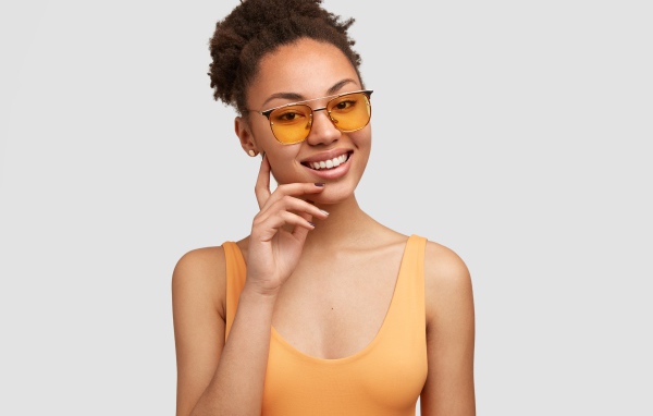 Красивая улыбающаяся темнокожая девушка в солнечных очках