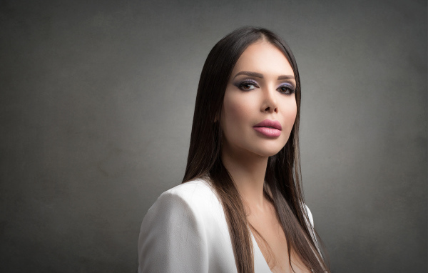 Блондинка с красивым макияжем на сером фоне