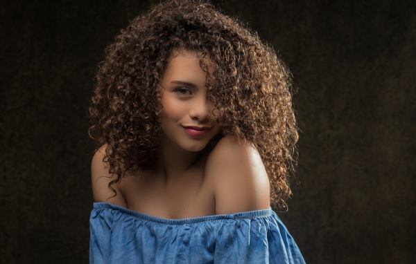 Милая кудрявая девушка в платье