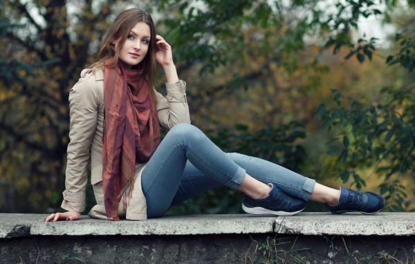 Милая девушка в куртке и синих джинсах 