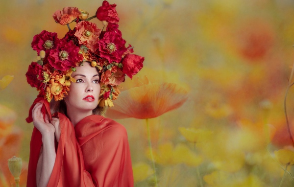 Милая девушка с венком из красных маков на голове