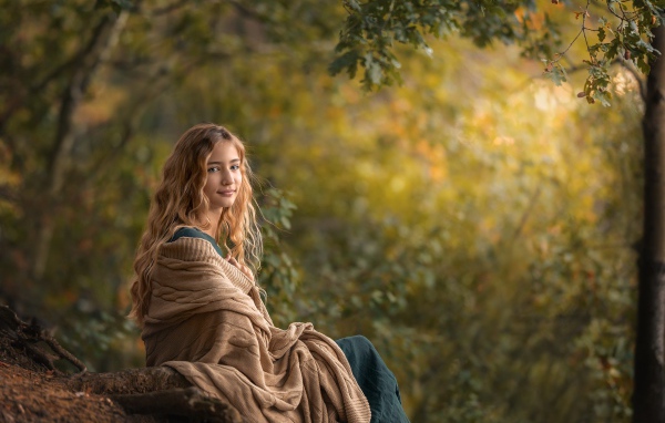 Милая длинноволосая девушка в теплой накидке 