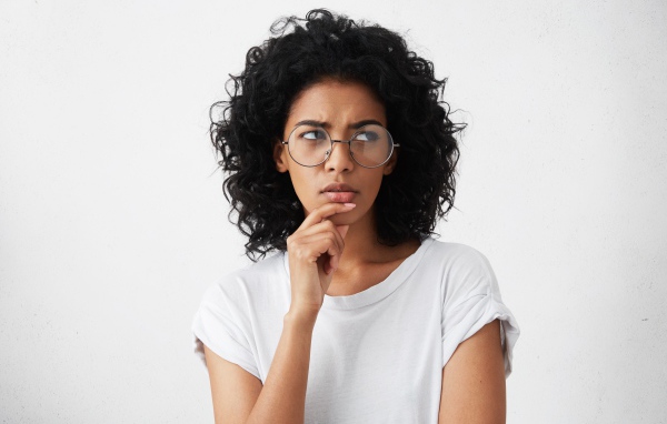 Темноволосая девушка в очках на сером фоне