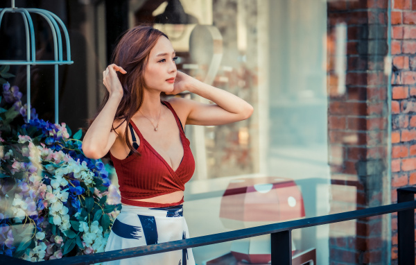 Нежная девушка азиатка стоит на балконе 