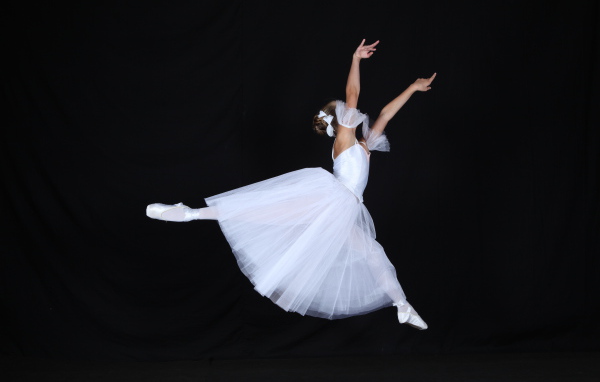 Девушка балерина в белом платье на черном фоне