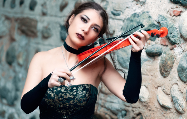 Девушка в черном платье со скрипкой в руке 
