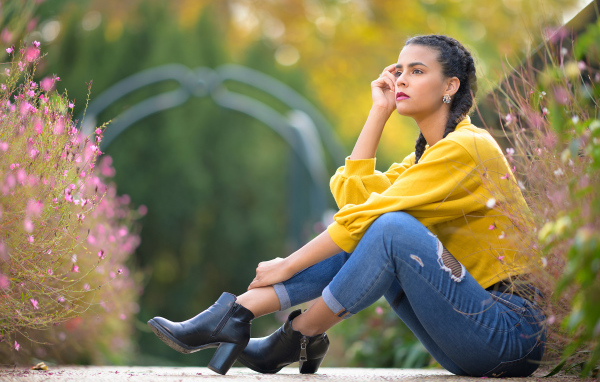 Девушка в джинсах сидит на земле 