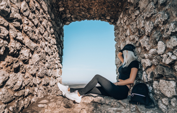 Девушка сидит в окне старого здания 