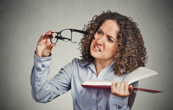 Девушка с книгой с очками в руке