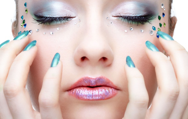 Девушка  с ярким макияжем и стразами на лице 
