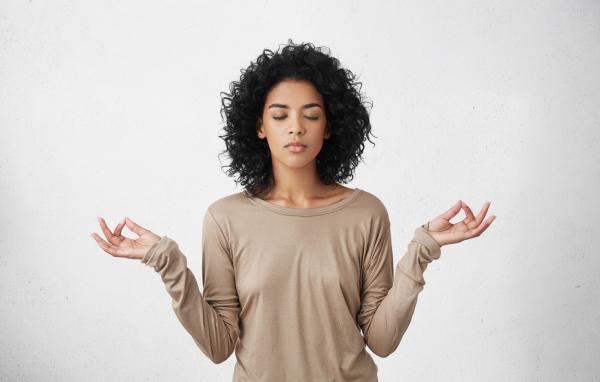 Девушка с закрытыми глазами медитирует 