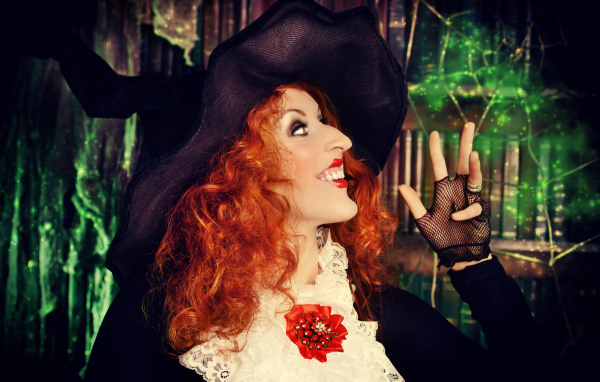 Halloween red-haired girl in a witch costume