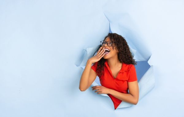 Радостная девушка прорвала дыру в стене