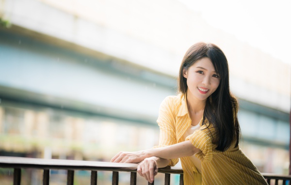 Улыбающаяся азиатка в желтой полосатой рубашке