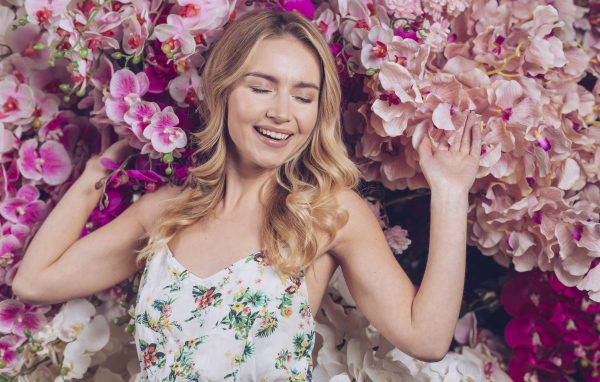 Улыбающаяся счастливая девушка у цветов орхидеи