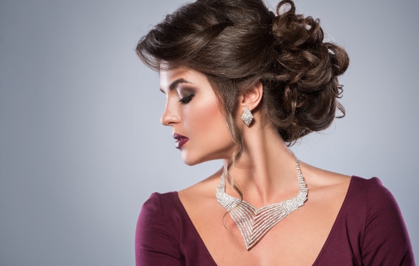 Стильная женщина с вечерней прической, макияжем и дорогими украшениями