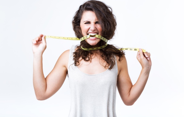 Блондинка в белой майке грызет сантиметр 