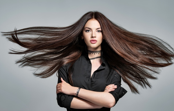 Ветер развивает волосы девушки в черной рубашке 