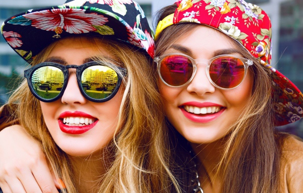 Две улыбающиеся девушки в солнечных лучах