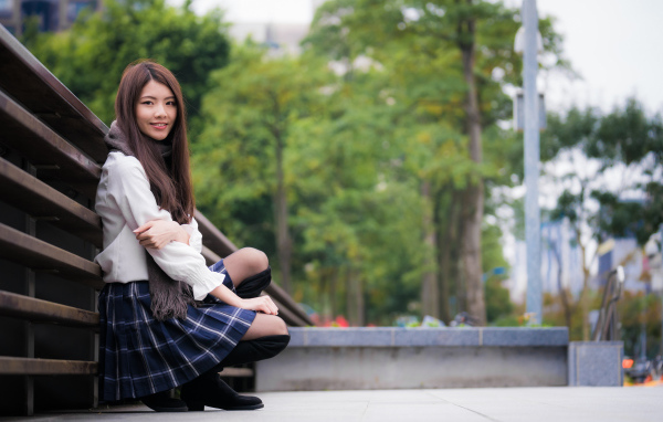 Молодая девушка азиатка в черных сапогах