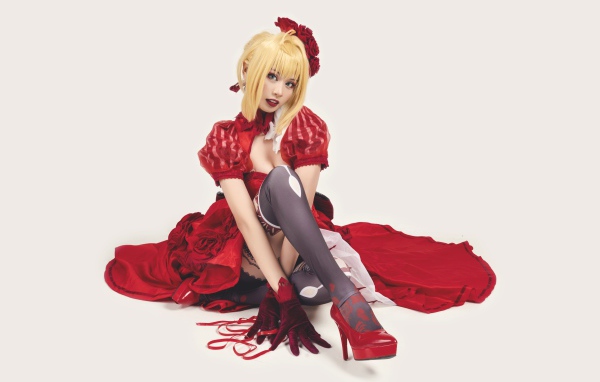 Молодая азиатка в ярком красном костюме на белом фоне