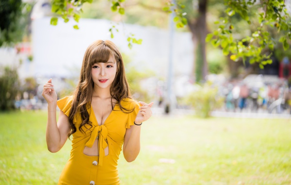 Молодая азиатка в желтом платье в парке