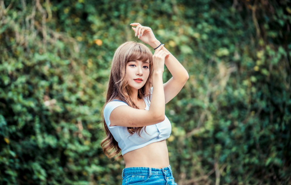 Молодая азиатка подняла руки вверх 