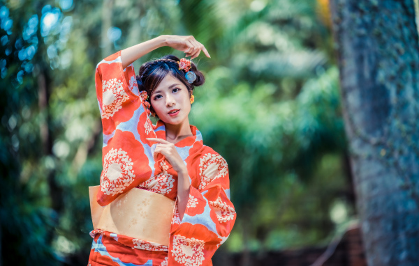 Молодая азиатка в кимоно в парке 