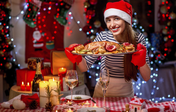 Девушка в костюме готовит угощения на новый год 