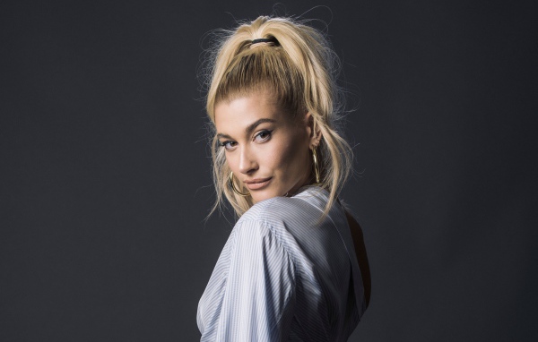 Красивая блондинка, американская модель Хейли Болдуин на сером фоне