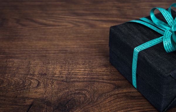 Gift with a blue bow on a wooden table