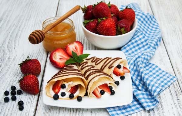Pancakes with sour cream, blueberries and strawberries on Maslenitsa