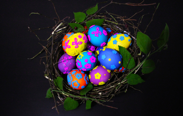 Красивые разноцветные яйца в гнезде на праздник Пасха