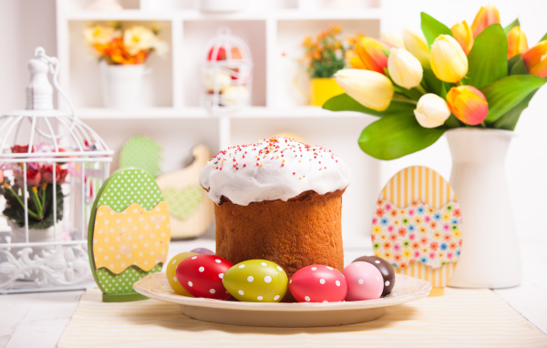 Кулич с яйцами на столе с букетом цветов на праздник Светлой Пасхи
