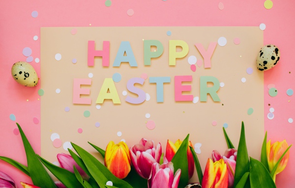 Надпись Счастливой Пасхи на столе с тюльпанами