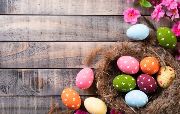 Разноцветные яйца в гнезде на столе на Великий православный праздник Пасха