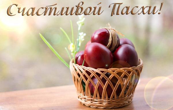 Красные крашеные яйца в корзине, открытка с надписью Счастливой Пасхи