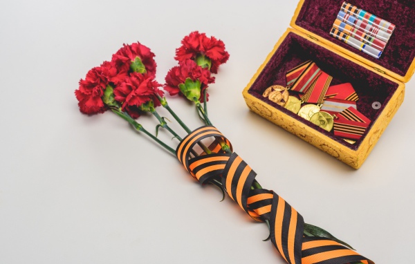Букет гвоздик с георгиевской лентой и наградами на День Победы 9 мая